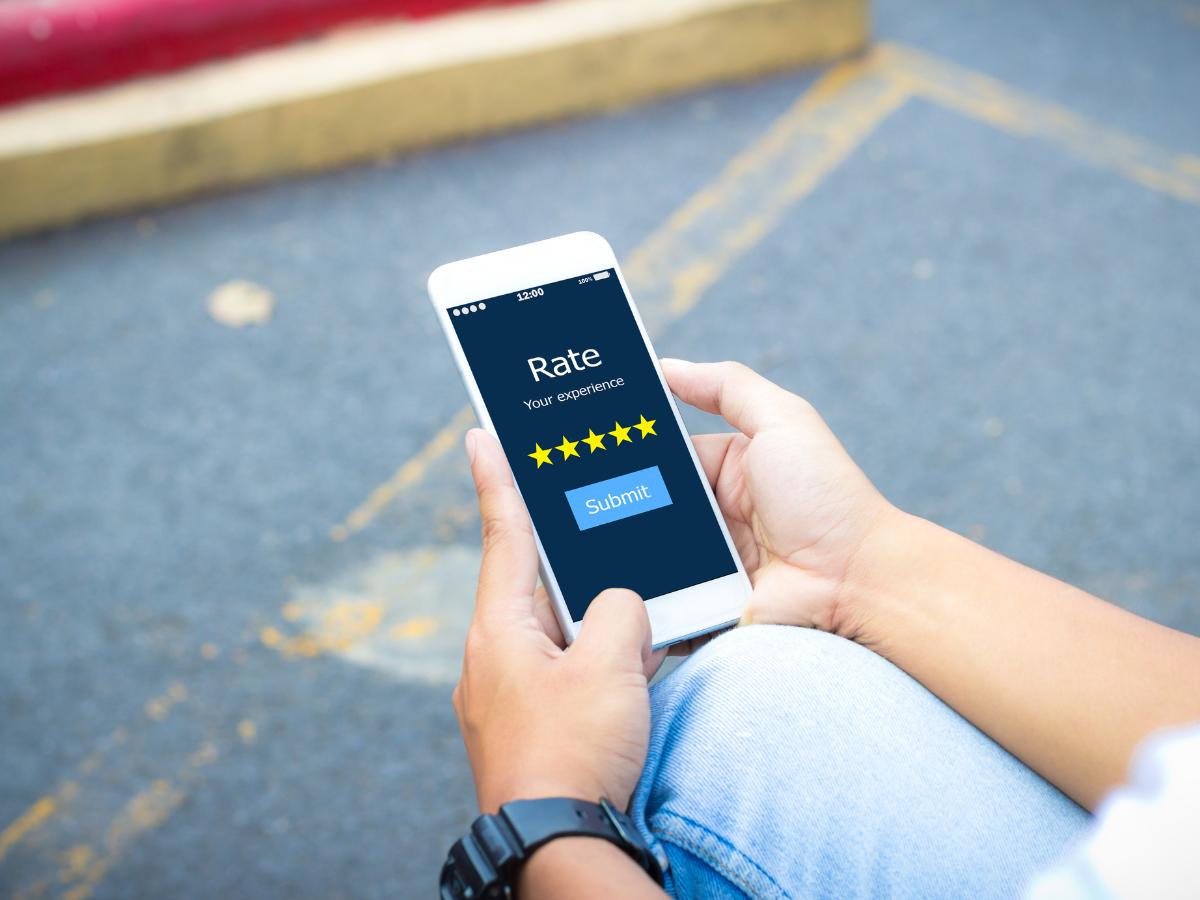 Customer submitting a five-star service review on a smartphone at Crain Buick GMC in Conway.